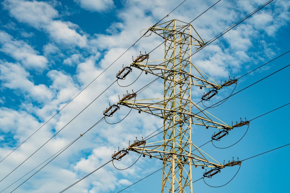 Torre de transmisión eléctrica con líneas de alta tensión y cielo azul