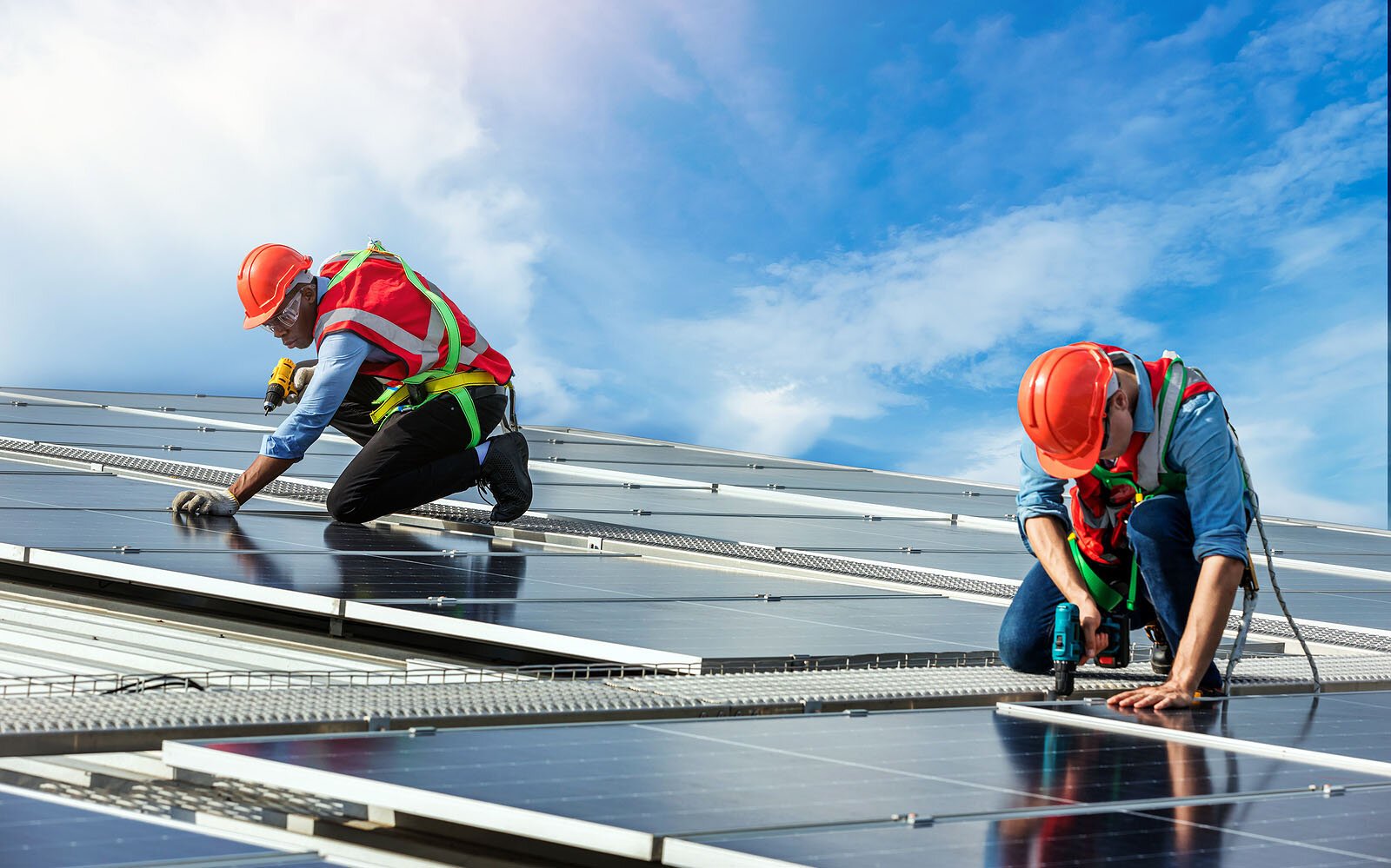Especialista supervisando la instalación de paneles solares en campo, laptop en mano