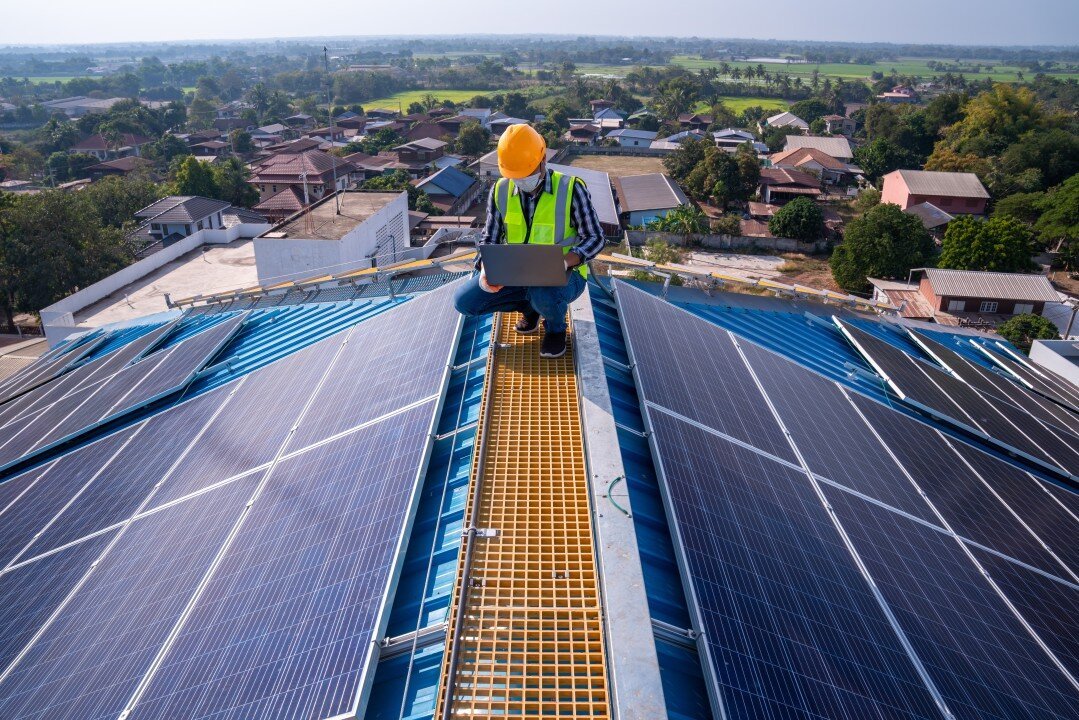 Técnicos instalando paneles solares sobre la estructura de un techo
